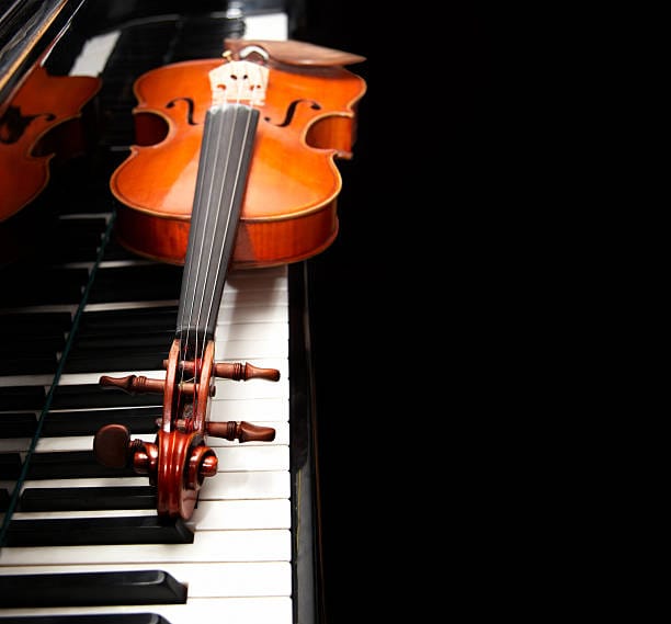 Violin on the piano on a black background